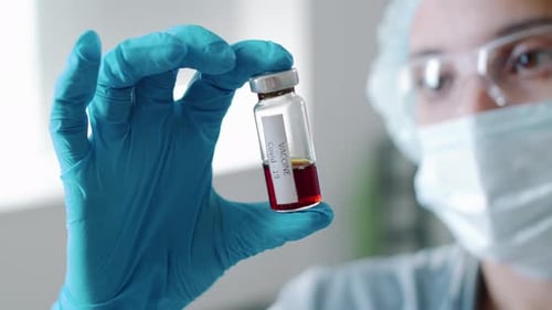 Medical Worker Holding COVID-19 Vaccine Vial
