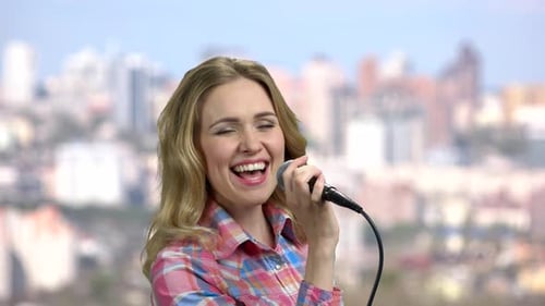 Woman Singing Happily with Microphone, City Background