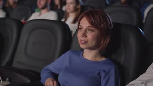 Mujer riendo en el cine, viendo comedia.