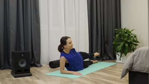 Woman Exercising Leg Lifts on Yoga Mat