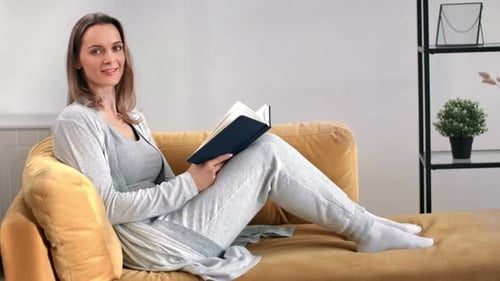 Woman reading a book while relaxing on sofa