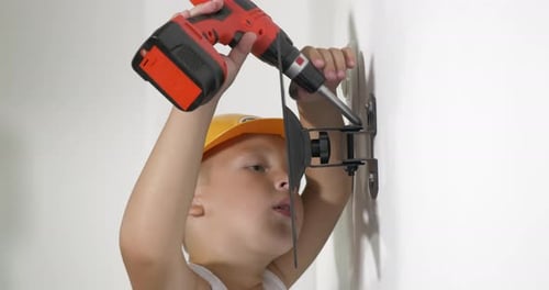 Niño trabajando con un destornillador eléctrico