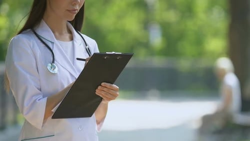 Doctor Writing on Clipboard in Green Park