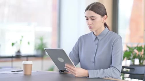 Young Woman Working on Tablet in Modern Office