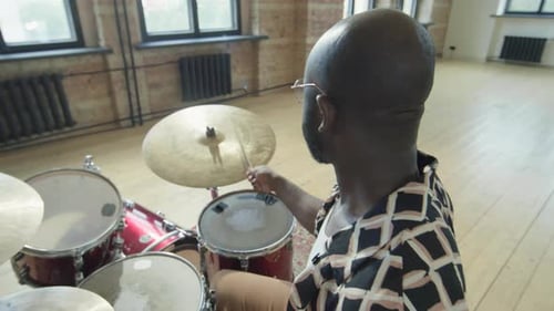 Músico afroamericano tocando la batería en el estudio de ensayo