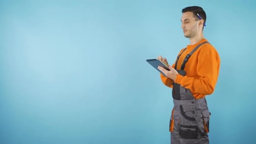 Yonug Worker with Tablet in Studio Blackground with Copy Space