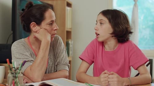 Woman Helps Teen Girl With Homework at Home