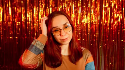 Thoughtful Woman Scratching Head Against Festive Orange Tinsel