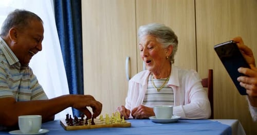 Senior Adults Playing Chess and Taking Photos