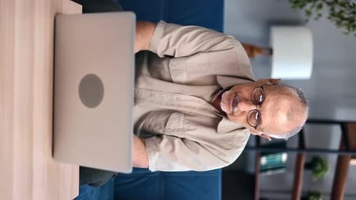 Senior Man Working on Laptop in Living Room