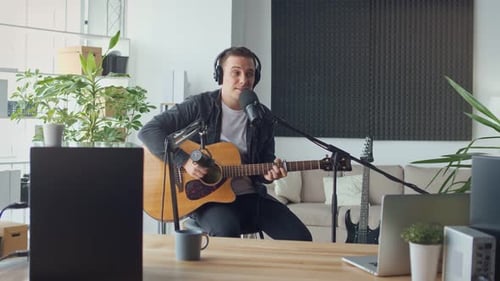 Young Man Playing Guitar and Singing at Home