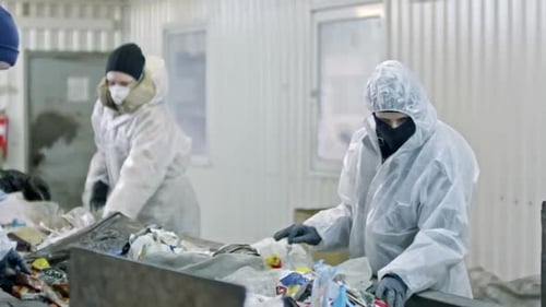 Recycling Plant Workers Sort Waste Material Indoors