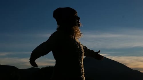 Feliz mujer libre, abre los brazos y disfruta de la increíble y hermosa puesta de sol en la montaña.