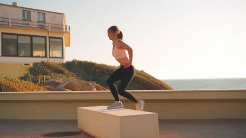 Woman Doing Step Exercises on a Wall by Ocean