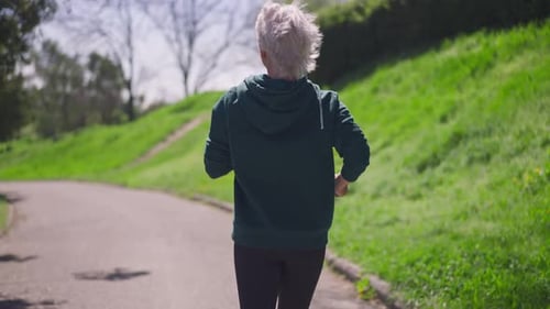 Senior Woman Jogging on Park Path