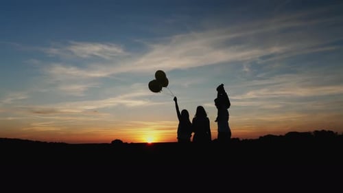 Silhouette Family Watching a Vivid Sunset Together