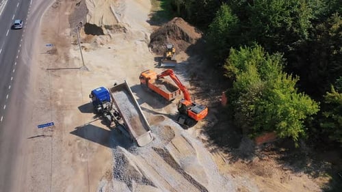 Excavator Loads Gravel into Dump Truck, Aerial View