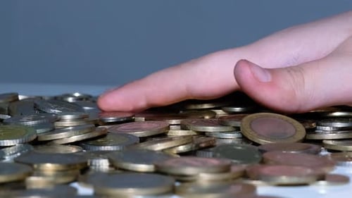 Hand Sorting Pile of Gold and Silver Coins