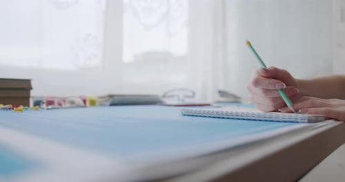 Hands Drawing Lines in Notepad with Ruler and Pencil