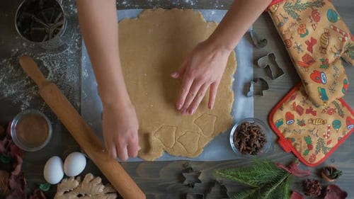 Top View of a Woman's Hand Making a Gingerbread Cookie. Christmas and New Year Concept