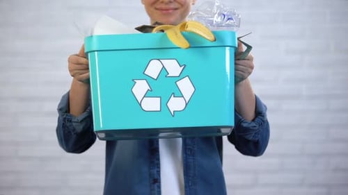 Person Holding Blue Recycling Bin Full of Trash
