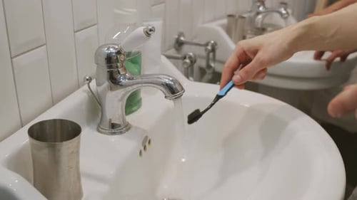 Brushing Teeth in a White Bathroom Sink