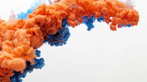 Red and Blue Ink in Water Mixed Close Up. White Background