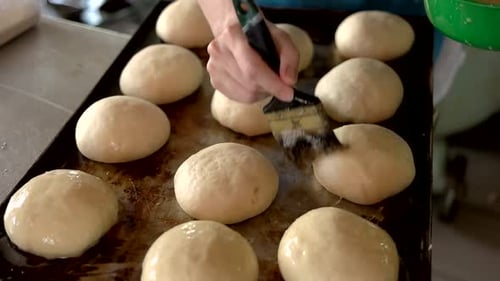 Bäckerin, die Teig mit Eigelb bestreichen
