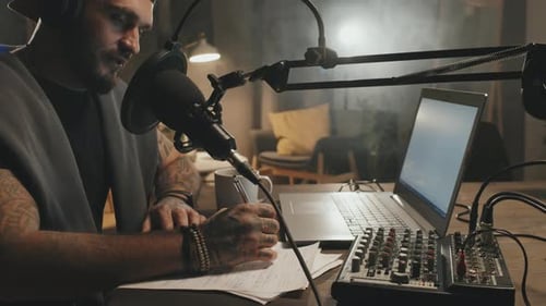 Podcaster Recording Audio in Home Studio at Night
