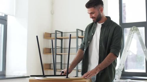Man Assembling Round Table with Screwdriver Indoors