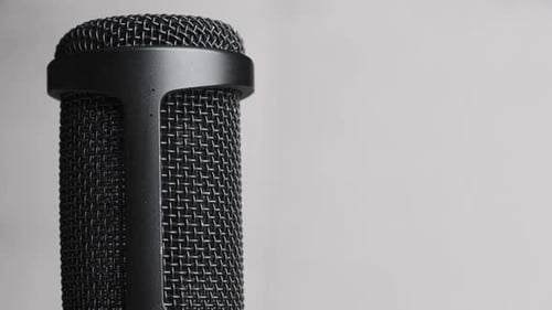 Studio Condenser Microphone Rotates on Gray Background with Place for Text