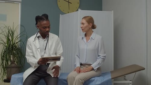 Doctor Consults with Patient in Exam Room