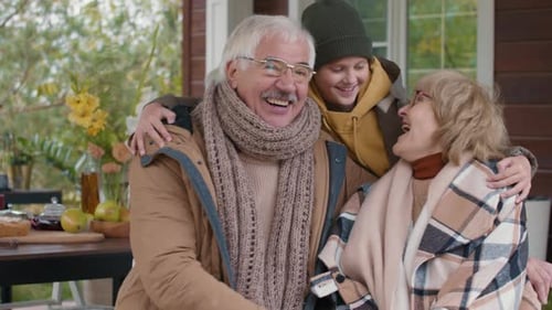 Grandparents and Grandson Laughing Together on Porch