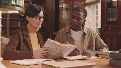 Professor and Student Studying Literature at Library