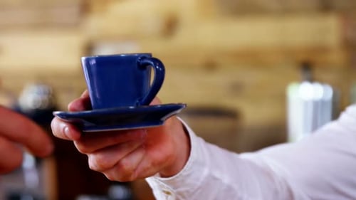 Passing a Coffee Cup to a Customer Close Up