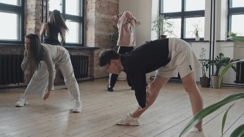 Young Adults Stretching in a Bright Studio