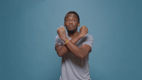 Young Adult Man Making Negative 'X' Arms Gesture