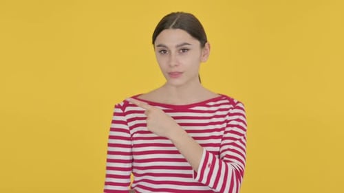 Woman Points to the Right and Smiles