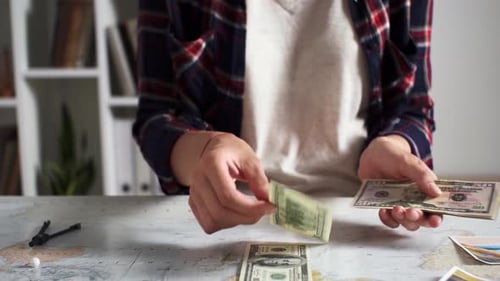 Person Counts US Currency on World Map