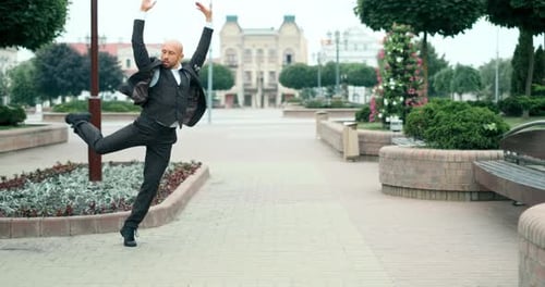 Homem de negócios alegre feliz em traje de negócios está dançando na rua, homem barbudo e alegre