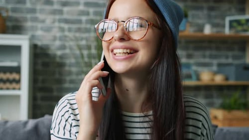 Smiling Woman Talks on Mobile Phone Indoors