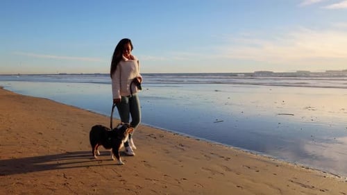 woman walking her dog on the beach
