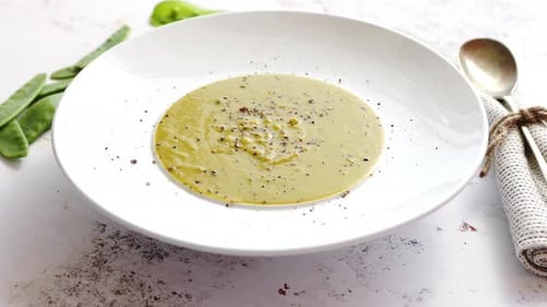 Creamy Soup with Green Pea in a Ceramic White Plate