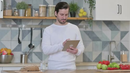 Adult Man Using Tablet in Modern Kitchen