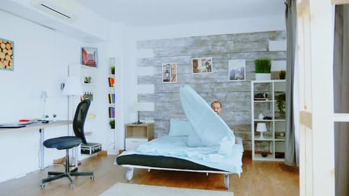 Man Wakes Up and Stretches in Bedroom