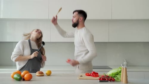 Couple Dancing in Kitchen with Ladle and Spoon