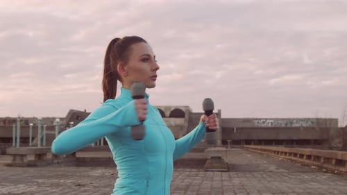 Woman Working Out with Dumbbells on Rooftop