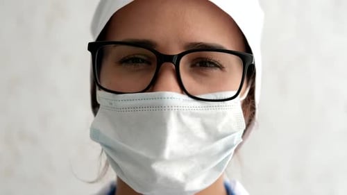Eine Krankenschwester mit Maske während einer Coronavirus-Pandemie. In Zeitlupe schließen.