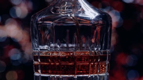 Whiskey Pouring into Glass Decanter Close Up