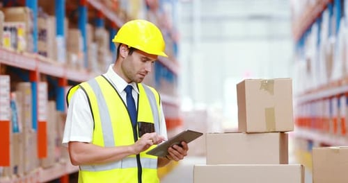 Male warehouse worker using digital tablet